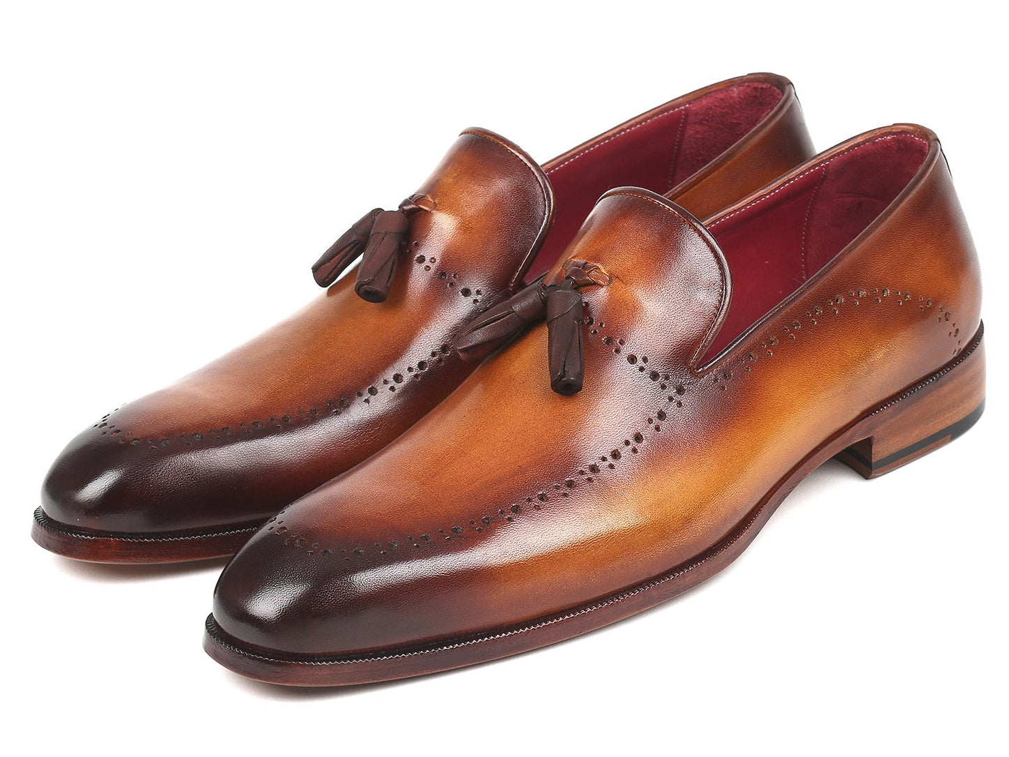 The Paul Parkman Tassel Loafer Brown - 66T81-BRW showcases hand-painted finesse and decorative perforations arranged in a crossed position on a pristine white background.