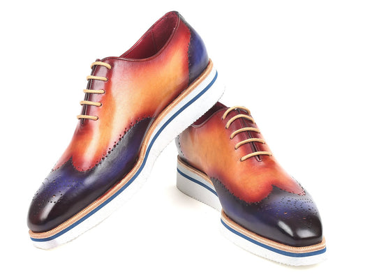 Experience style and sophistication with the Paul Parkman Smart Casual Wingtip Oxfords in Blue & Camel (188-BLU-CML). These multicolored shoes boast handpainted uppers featuring a stunning gradient design transitioning from orange to purple. They are complemented by wingtip leather lining, white soles, and tan laces for a unique, fashionable look.