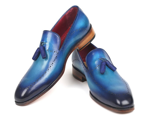 The Paul Parkman Tassel Loafer Blue - 66T82-BLU is a bespoke pair of blue leather loafers featuring a gradient finish and decorative perforations, complete with wooden soles and an eye-catching red interior lining.