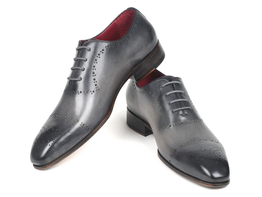 The Paul Parkman Grey Hand-Painted Classic Brogues - ZLS34GRY from Paul Parkman showcase intricate decorative perforations, a red interior lining, and a sleek leather sole, all presented against a white backdrop.
