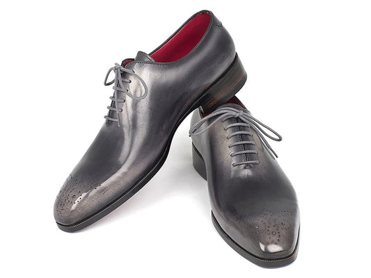 The Paul Parkman Gray & Black Wholecut Oxfords (KR254GRY), with their sleek gray leather and lace-up design, feature subtle perforations on the medallion toe caps, all set against a white background.