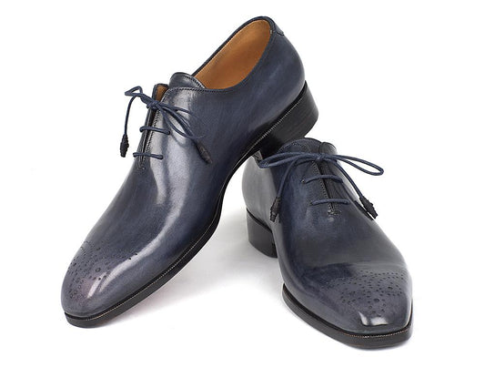 The Paul Parkman Navy Wholecut Oxfords - KR254NVY are a pair of handmade shoes crafted in glossy navy calfskin, complete with laces and decorative perforations on the toes.