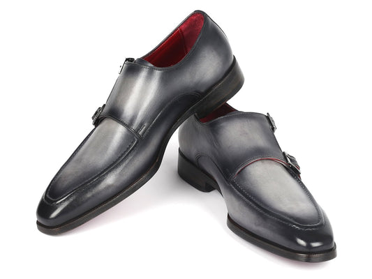 A pair of elegant, polished gray leather double monkstrap shoes by Paul Parkman, featuring silver buckles and a striking red interior lining, meticulously crafted as a made-to-order product.