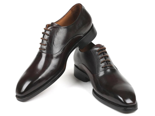 A pair of Paul Parkman Plain Toe Oxfords in brown, featuring a closed lace-up design, meticulously crafted from hand-painted leather, with one shoe slightly elevated above the other.