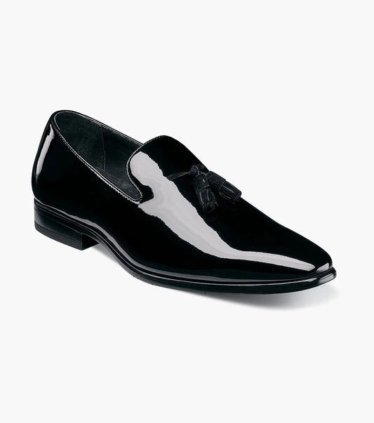 The Stacy Adams Phoenix Plain Toe Tassel Slip On (Black Patent, 21011-004) features a black patent upper, low heel, memory foam footbed, and slightly pointed toe. Shown: single loafer with tassel on white background.