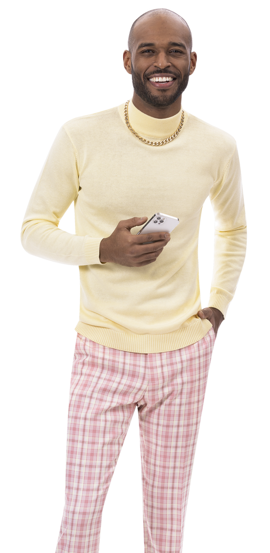 A man wearing EJ Samuel Mauve Plaid Pants PL139 by EJ SAMUEL and a yellow sweater holds a smartphone and smiles.