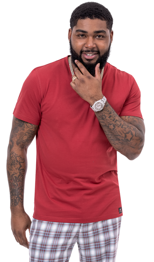 A man in a red t-shirt and EJ SAMUEL's modern fit EJ Samuel Burg/Moss Plaid Pants PL90 smiles, with a hand on his chin.