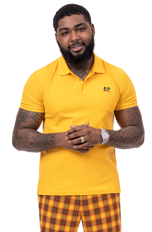 A bearded man in a yellow polo shirt stands with his hands clasped, wearing EJ Samuel Rust Plaid Pants PL98.