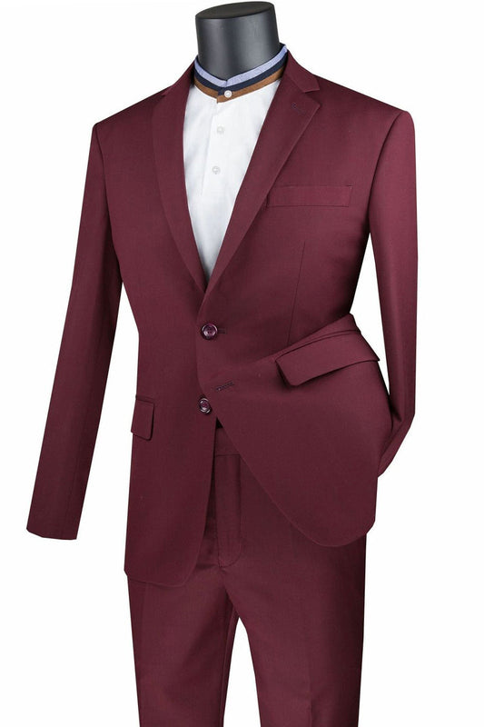 Vinci Suits' Slim Fit 2 Piece 2 Button Suit (Burgundy) SC900-12 is showcased on a mannequin. The jacket, complete with a single breast pocket and button closure, pairs seamlessly with matching trousers. A white shirt with a stylized collar completes the wrinkle-resistant, sharp ensemble.