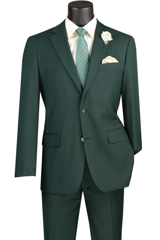 A Vinci Suits slim fit 2 piece, 2 button suit in hunter green (SC900-12) adorns the mannequin, paired with a white shirt, plaid green tie, and floral boutonnière. This wrinkle-resistant outfit exudes sophistication.