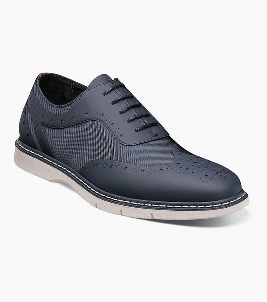 The STACY ADAMS Summit Wingtip Lace Up (Navy, 25434-410) features a leather and ripstop nylon upper, mesh side panels, and decorative perforations on a dark blue oxford with light-colored sole and visible stitching for stylish durability.