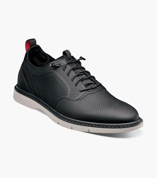The Stacy Adams Synchro Plain Toe Elastic Lace Up in black features perforated detailing, elastic black laces, and a white sole. This low-top dress and casual shoe by STACY ADAMS is shown on a plain white background.