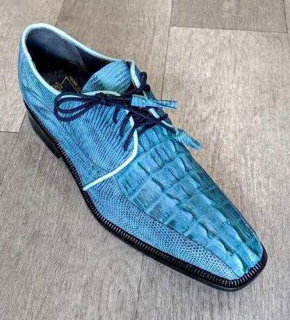 The Romano by Los Altos Genuine Croc/Lizard Raptor in a rustic black-blue shade, featuring black laces, rests elegantly on the wooden floor.