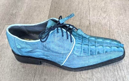 The Romano by Los Altos Genuine Croc/Lizard Raptor in a rustic black-blue shade, featuring black laces, rests elegantly on the wooden floor.