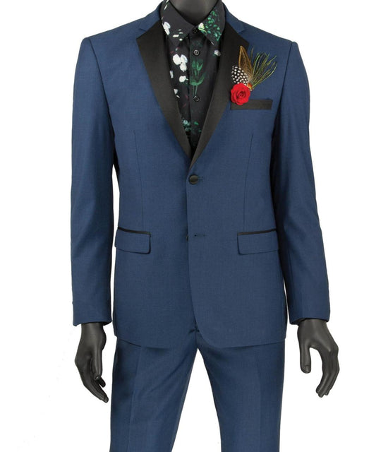 The Vinci Suits Ultra Slim Fit 2 Buttons T-US900 blue tuxedo features black lapels and comes with a floral black shirt. This wrinkle-resistant set, complete with a pocket square fashioned with a red rose and feathers, is showcased on a sleek black mannequin.