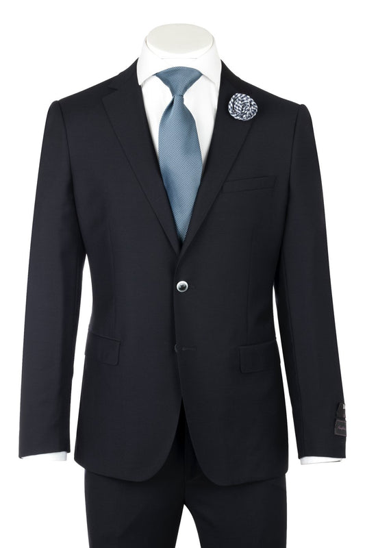 A dark navy suit by Tiglio Luxe, offering European styling, paired with a white dress shirt, blue tie, and decorative lapel pin. The Porto Slim Fit suit is crafted from pure wool for an elegant appearance using luxurious Italian fabrics.