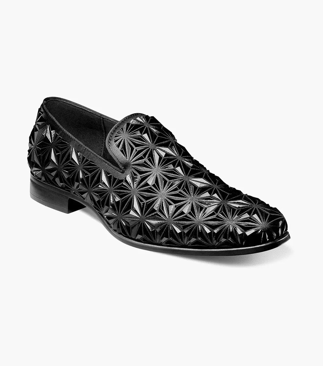 The Stacy Adams Sequence Plain Toe Slip On (25535-001) is a black dress shoe with a glossy geometric star pattern, memory foam insole, and low heel, shown against a plain white background.