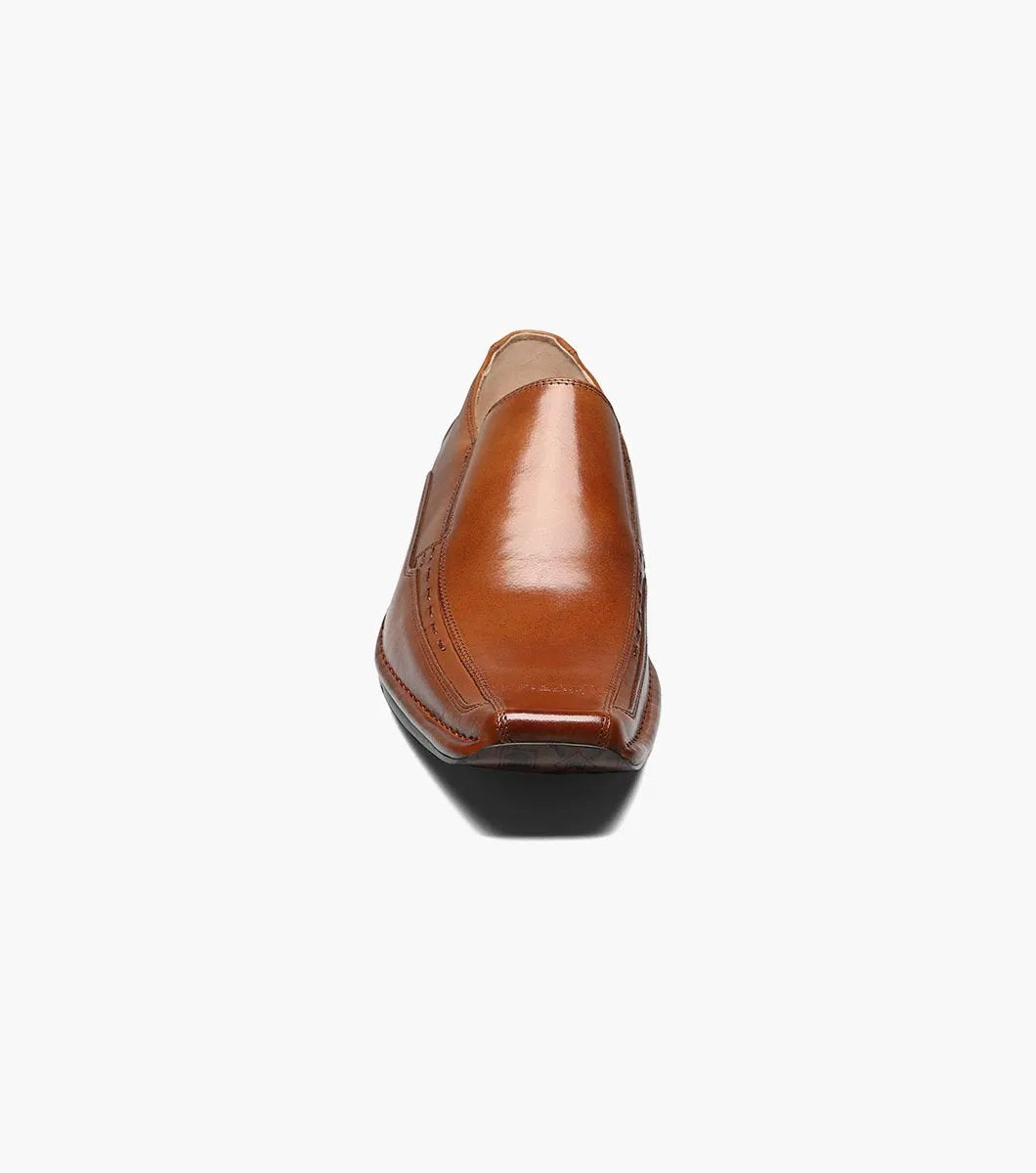 The Stacy Adams Templin Bike Toe Loafer in cognac (24507-221) features brown genuine leather, a pointed toe, low black heel, and decorative stitching—a classic slip-on dress shoe by STACY ADAMS.