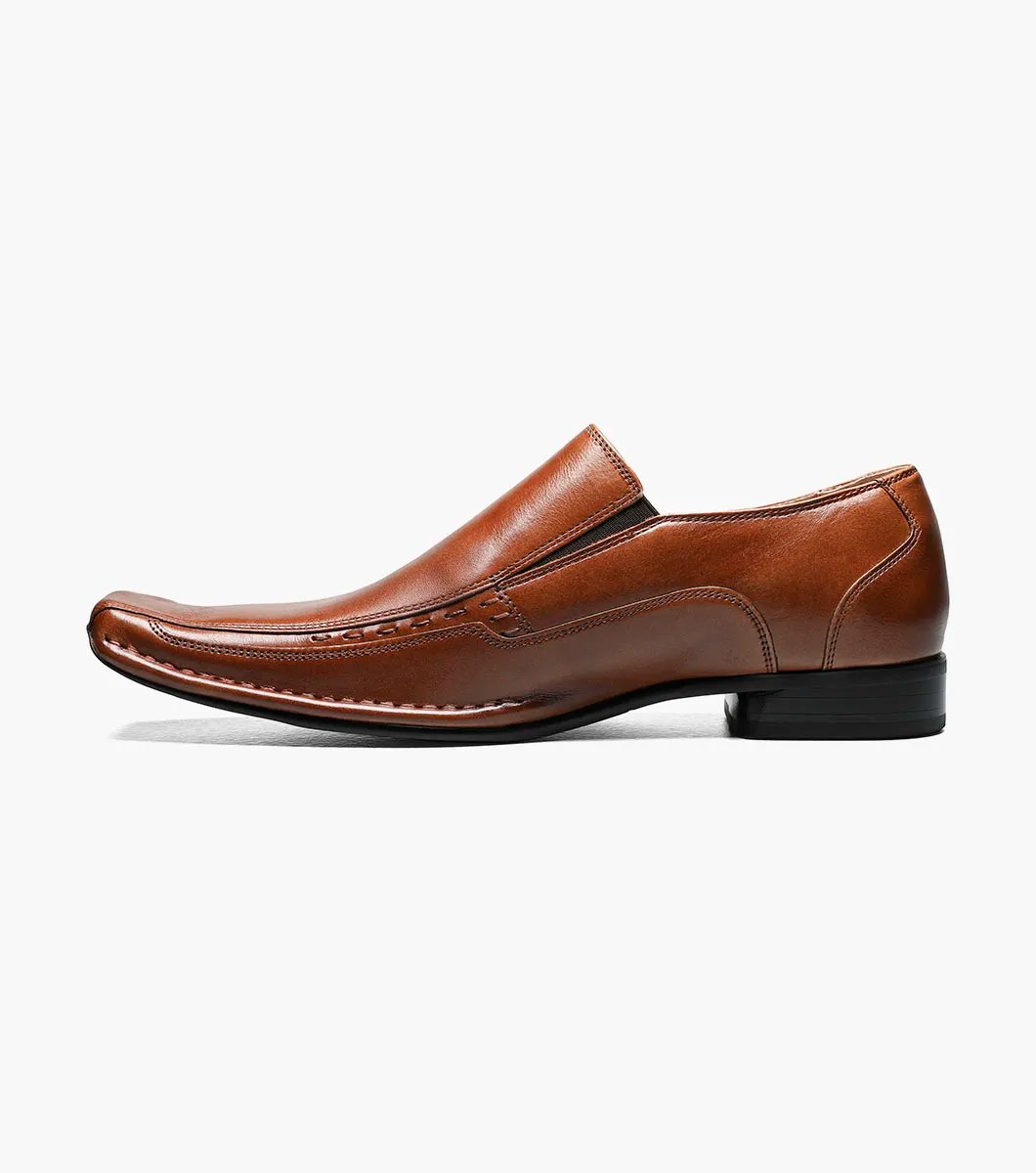 The Stacy Adams Templin Bike Toe Loafer in cognac (24507-221) features brown genuine leather, a pointed toe, low black heel, and decorative stitching—a classic slip-on dress shoe by STACY ADAMS.