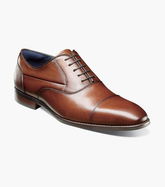 The STACY ADAMS Kallum Cap Toe Oxford in Cognac (25568-221) is a brown men's dress shoe with a cushioned footbed and dark laces, shown on a white background.